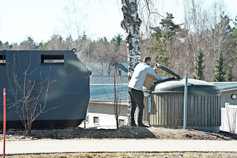 Koponen tyhjensi pahvilaatikon jätesäiliöön. Hän heitteli kirjat huolellisesti oikealla kädellään säiliön perukoille.