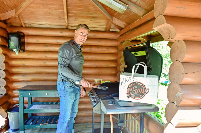 Mökillä Raipe viihtyy grillin äärellä. – Lihaa tulee grillailtua, kala-allerginen kiekkomies virnistää. Tällä kertaa grillailuun ei ollut tarvetta, sillä pöydän koristivat kanansiivistään tunnetun ravintola Hookin purtavat.