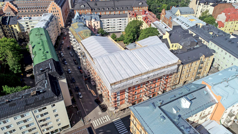 Jaren rakennusprojektin laajuus näkyy hyvin tässä ilmakuvassa. Uudet ullakkohuoneistot valmistuvat valkoisten pressujen alle.