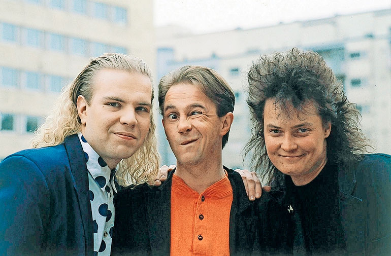 Hannu "Enzo" Pulkkinen (keskellä) on tullut tunnetuksi Hausmyllyyhtyeen laulajana. Kuva on vuodelta 1992.
