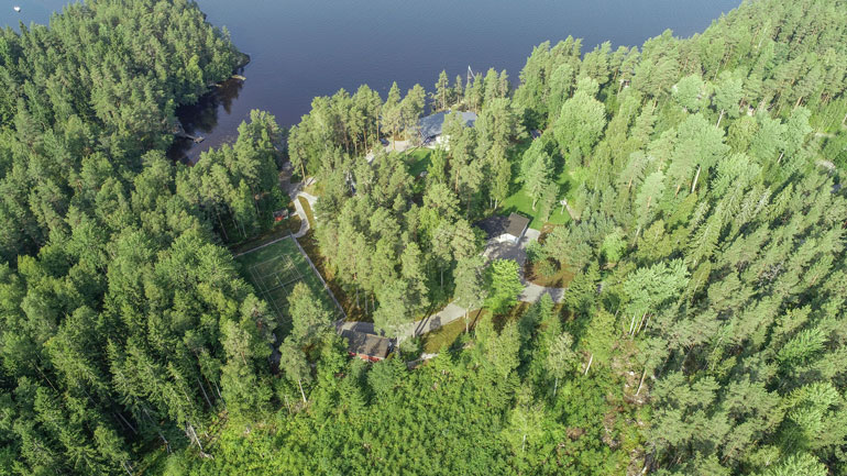 Huvilan takana on tenniskenttä huoltorakennuksineen.