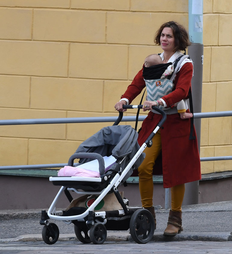 Manuela kuljetti pienokaistaan Helsingin keskustassa vakavailmeisenä.