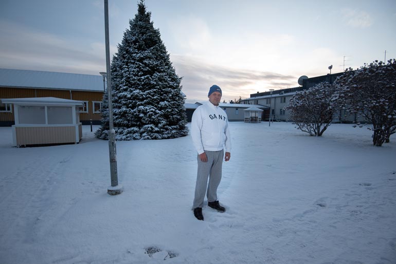 Vankilan pihalla on joulukuusi, jonka lamput syttyvät hämärässä.