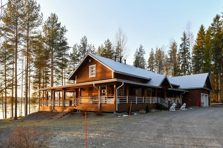 Hulppean, amerikkalaisiakin tyylivaikutteita saaneen hirsilinnan portailla vahtia pitää kaksi betonista leijonaveistosta.