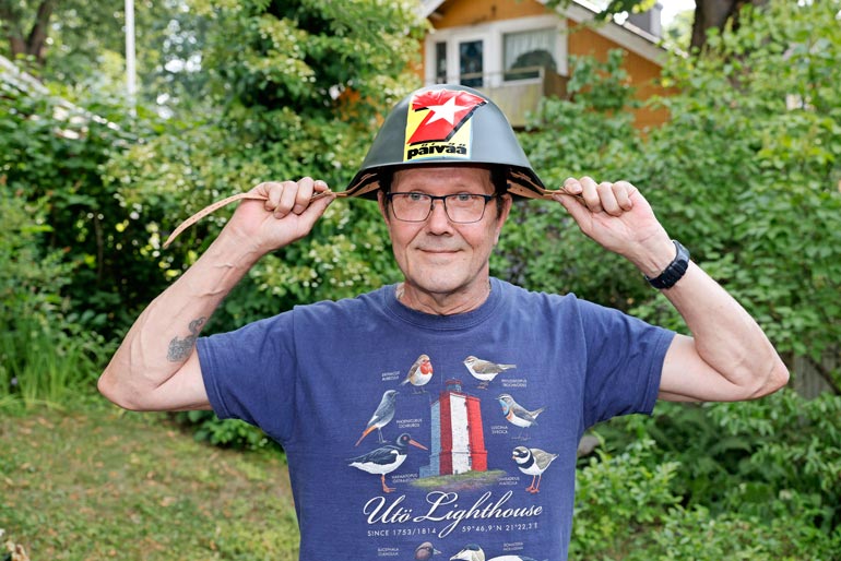 – Tämä täytyy ottaa mukaan kesämökille, niin eiköhän pää ole sitten turvassa, Erkki vitsailee Seiskalta saamansa sotilaskypärä päässään.
