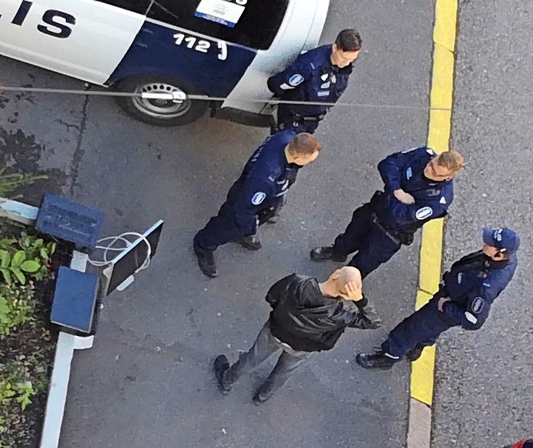 Riku poliisien ympäröimänä.