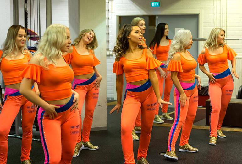 Cheerleaderit kuivaharjoittelevat tanssiliikkeensä kuntosalilla ennen varsinaisen ottelun alkamista.