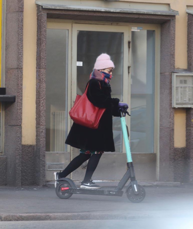 Vauvamasusta huolimatta Helmi-Leena suihki vauhdikkaasti sähköpotkulaudalla. Hän piti kaulaliinaa hengityssuojaimena.